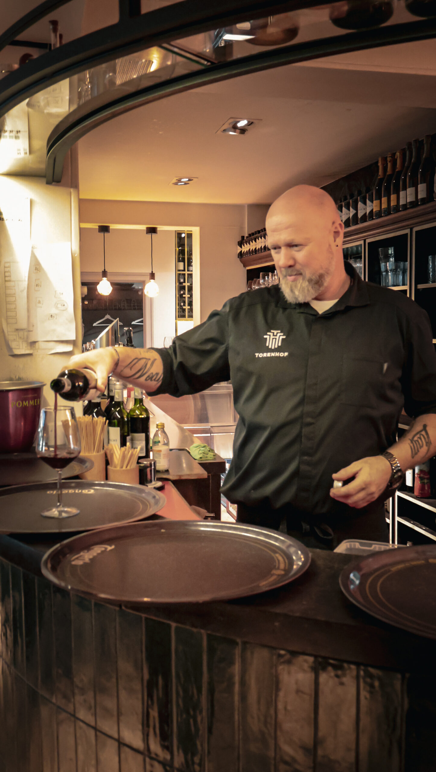 Barman schenkt wijn aan de bar van Torenhof