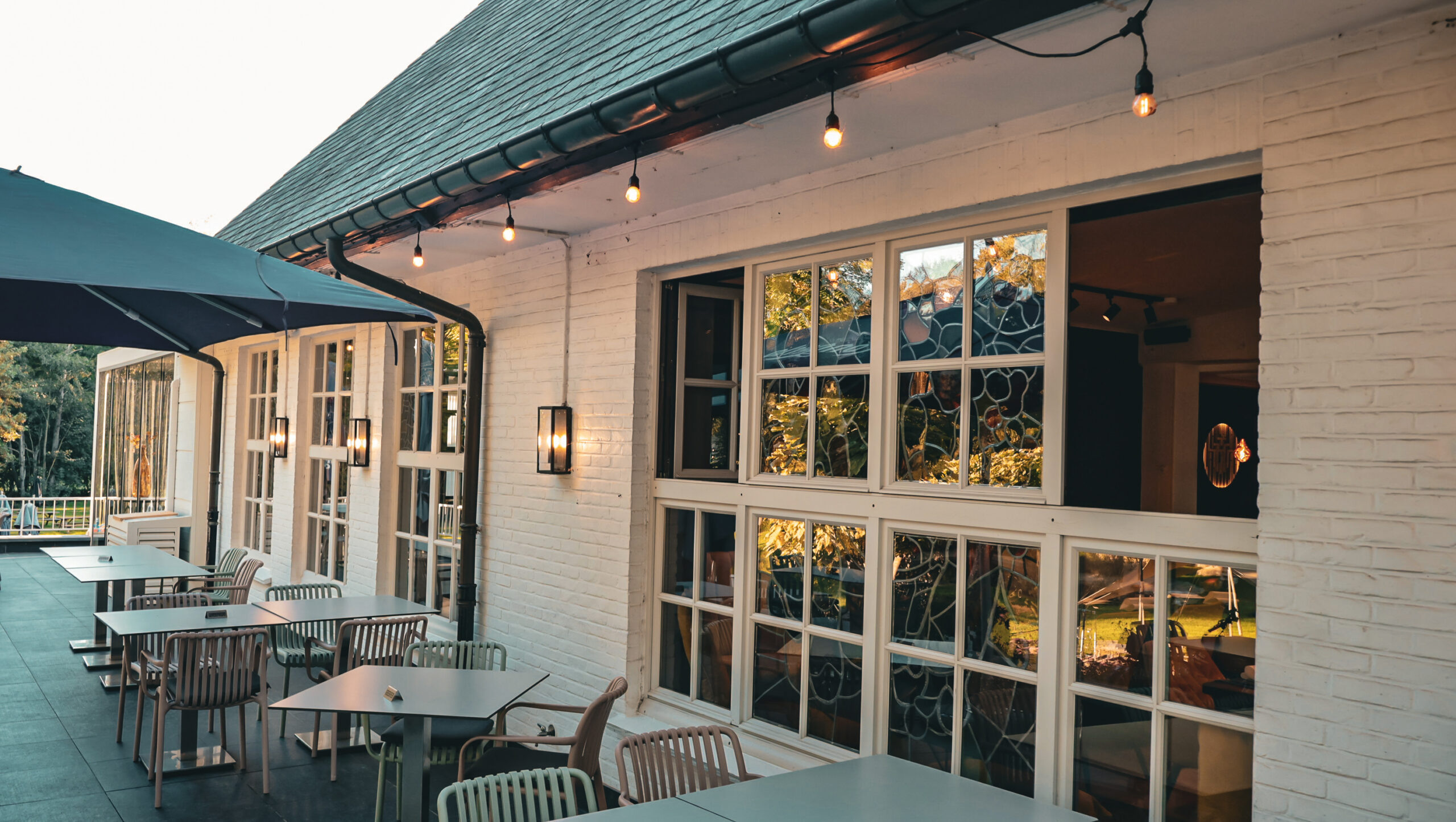 Het buitenterras van Torenhof Bistro met warme verlichting en glasramen